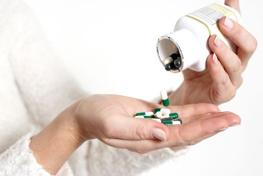 Closeup on woman's hands with pills and pill container