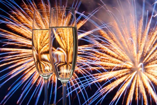 Glasses with champagne against fireworks 