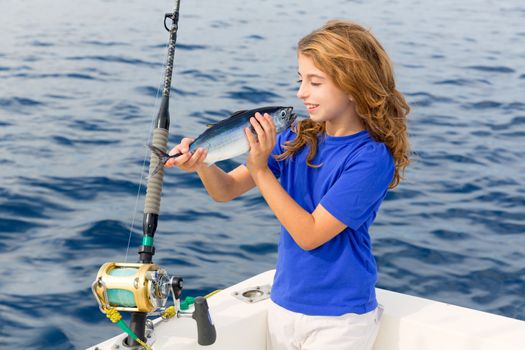 Blond girl fishing bluefin tuna trolling in Mediterranean sea catch and release