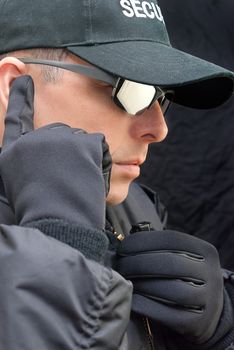 Close-up of a close protection officer listening to his earpiece.
