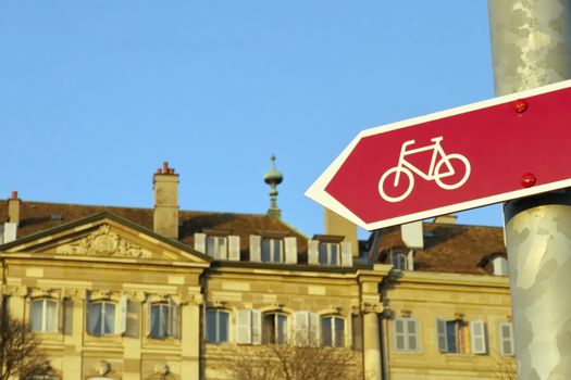 Close up on a bicycle signpost in front of old buildings, Geneva, Switzerland