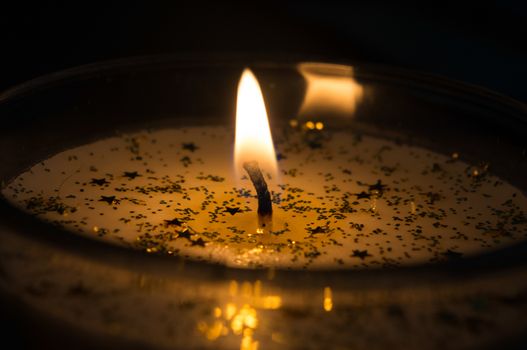 White Christmas candle decorated with golden stars