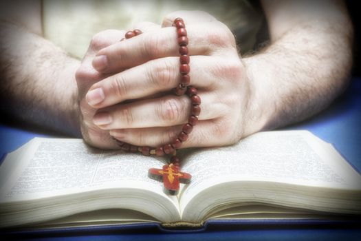 Christian believer praying to God with rosary in hand