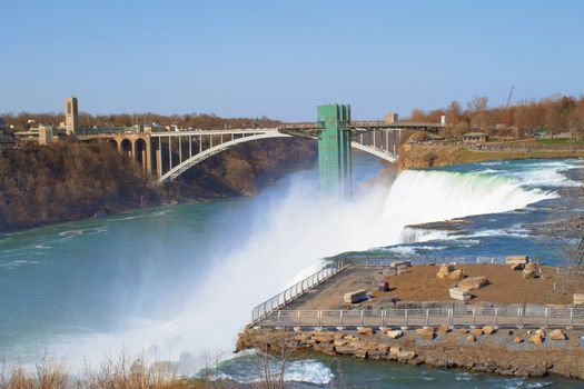 Niagara Falls pours into the river. This wonder of the world is located near the Rainbow Bridge which is seen in the distance. 