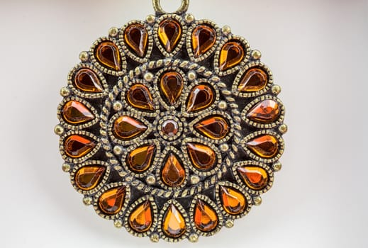 Sparkling orange gems adorn this bronzed circular neck piece. 
