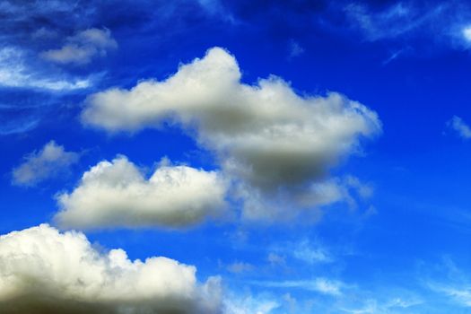 Wispy cloud formation attracts more moisture. The sky is a vivid blue. 