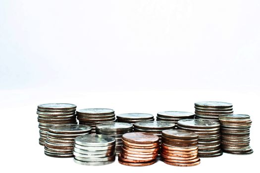 Thirteen stacks of coins ranging from pennies to quarter varying heights. Majority are quarters.