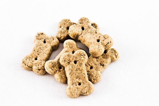 Bone shaped brown dog biscuits on white.