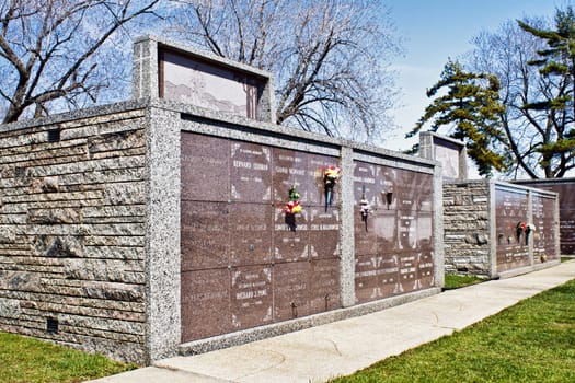 Community mausoleum at local graveyard. Flowers are placed at different burial tombs.