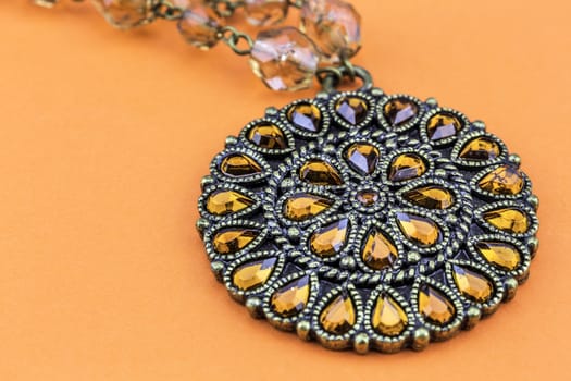 Beautiful gemmed necklace on orange background.
