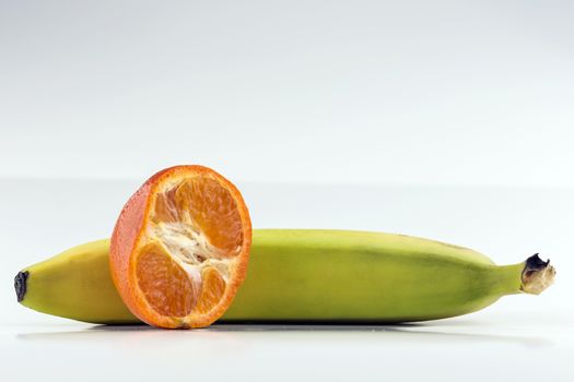 Halved orange propped up on banana.