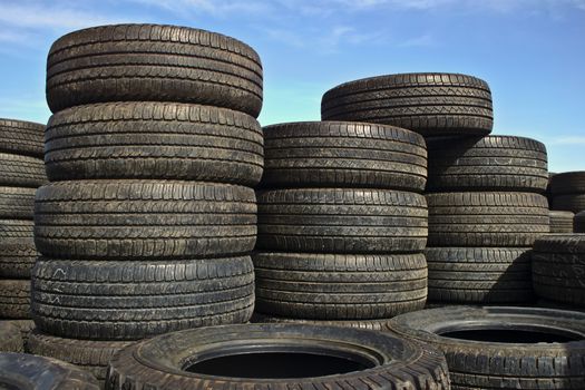 Stacks of car tires with blue sky