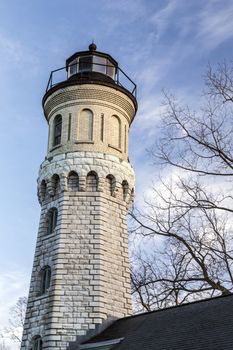 Historic Fort Niagara lighthouse tower against bright blue winter sky.