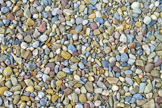 Closeup of water worn beach stones with differing shapes, sizes, and colors. Interesting texture.