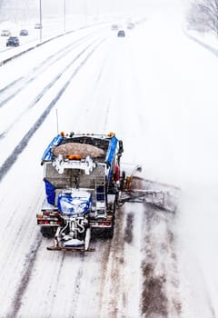 Snowplow Truck Removing the Snow from the Highway during a Cold Snowstorm Winter Day