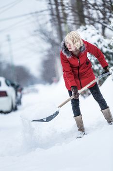 Woman Shoveling her Parking Lot after a Snowstorm