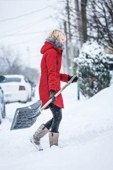 Woman Shoveling her Parking Lot after a Snowstorm