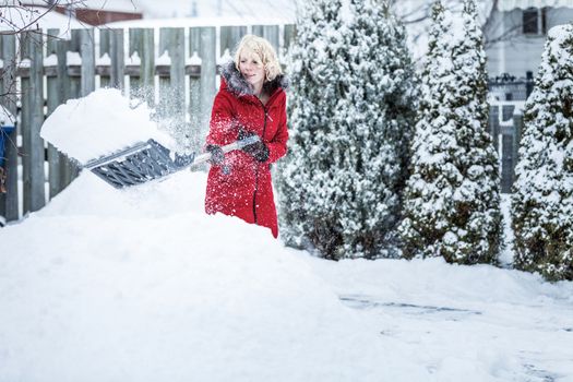 Woman Shoveling her Parking Lot after a Snowstorm