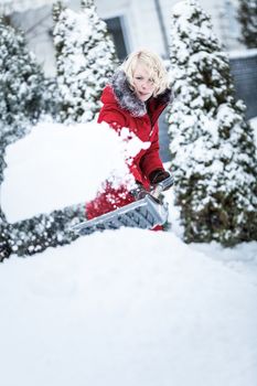 Woman Shoveling her Parking Lot after a Snowstorm