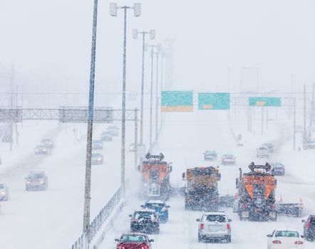 Tree Lined-up Snowplows Removing the Swno the Highway on a Cold Snowy Winter Day