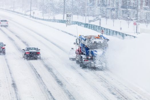 Snowplow Truck Removing the Snow from the Highway during a Cold Snowstorm Winter Day