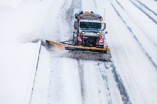 Snowplow Truck Removing the Snow from the Highway during a Cold Snowstorm Winter Day