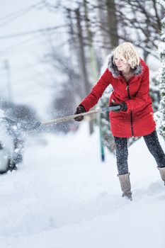 Woman Shoveling her Parking Lot after a Snowstorm