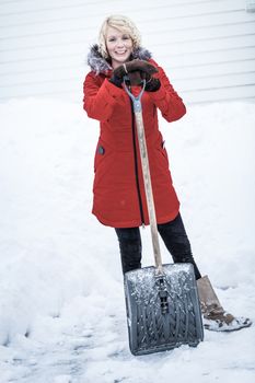 Happy Woman with a Shovel in a Parking lot. She's done with shoveling for today !