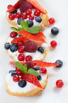 Profiteroles with berries currant  strawberries and blueberries