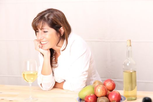 A beautiful mature woman with a glass of white wine.