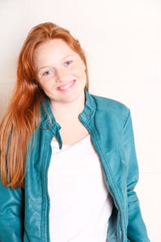 A attractive young, redhead woman with a green jacket.  
