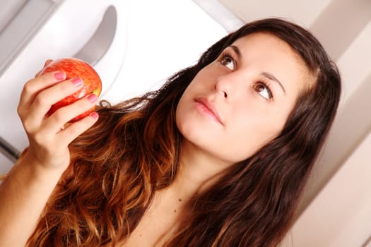 A young adult woman holding a Apple.