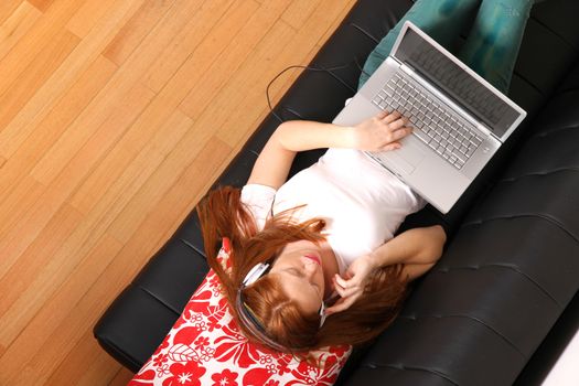 A young woman surfing on the Internet with a Laptop.  