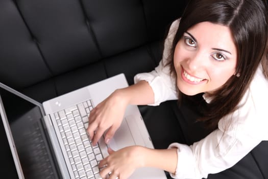 A young woman surfing on the Internet with a Laptop.  