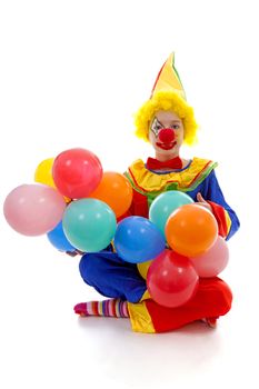 child dressed as colorful funny clown with balloons over white background