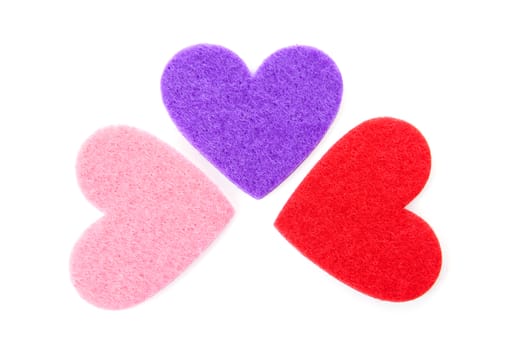 Three hearts made of felt over white background