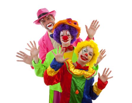 Three people dressed up as colorful funny clowns over white background