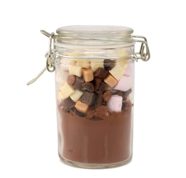 Ingredients for hot chocolate - cocoa, marshmallows, fudge pieces - in a glass jar, isolated on a white background