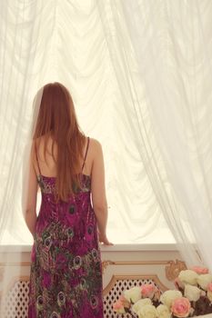 Woman in front of window.