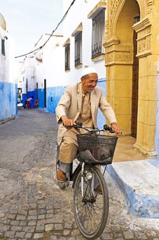RABAT, MOROCCO - OCTOBER 15 2013: Arab man is biking in the medina of Rabat Morocco