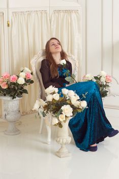 girl in a dress standing near the screen with flowers