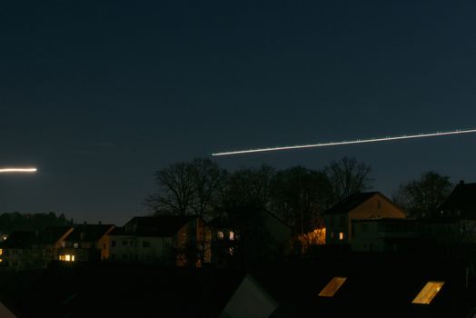 Jet airplanes are departing at night and leaving light traces, long exposure shot