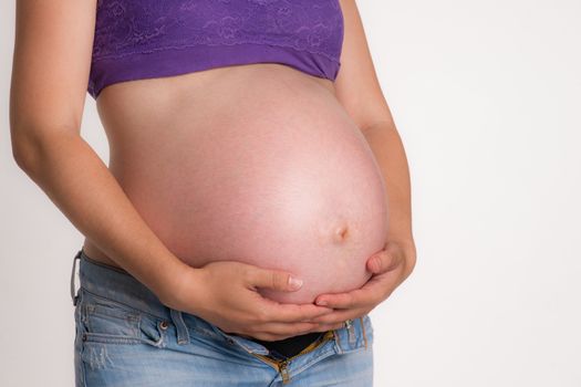 A woman tries to support her belly enduring pregnancy