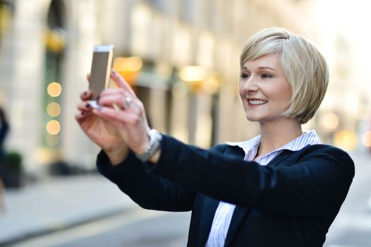 Corporate lady clicking her pic, outdoors