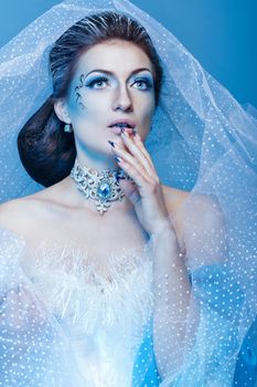 Young girl with a theatrical make-up as a fairy snow queen