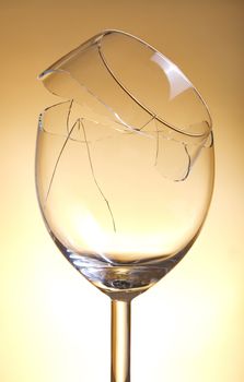 Broken vine glass on orange background