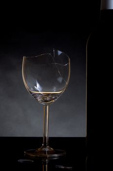 Vine bottle and broken glass on dark background