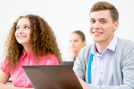 Portrait of a young student in the classroom, working with a laptop