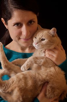 Girl with black hair holding a ginger cat