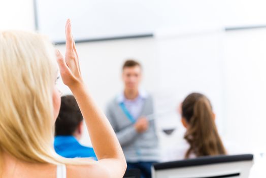 image of a female hand raised in university classroom